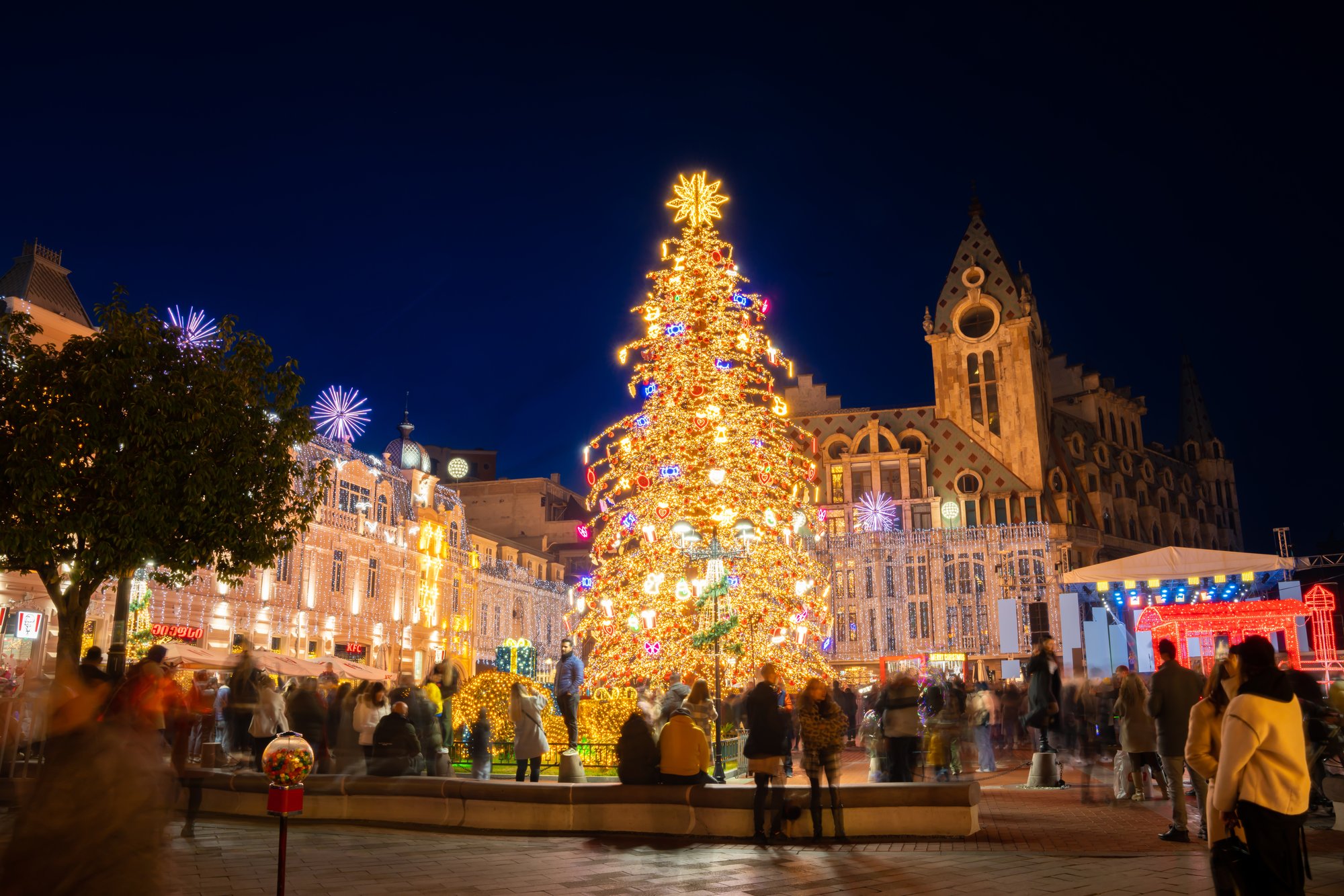 Albero natalizio illuminato con le persone nella piazza