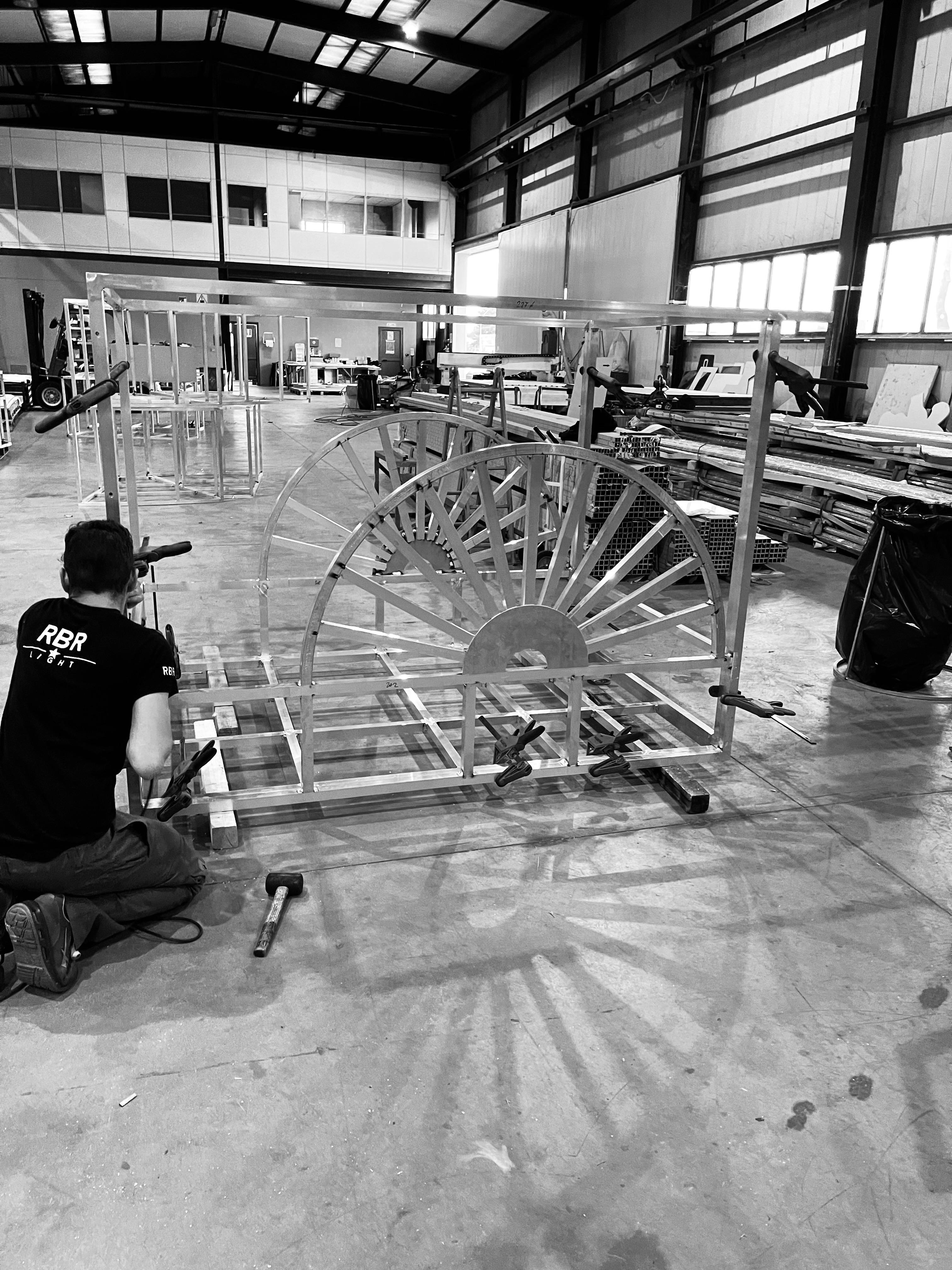 Un artigiano RBR costruisce una struttura metallica nel laboratorio, fotografia in bianco e nero
