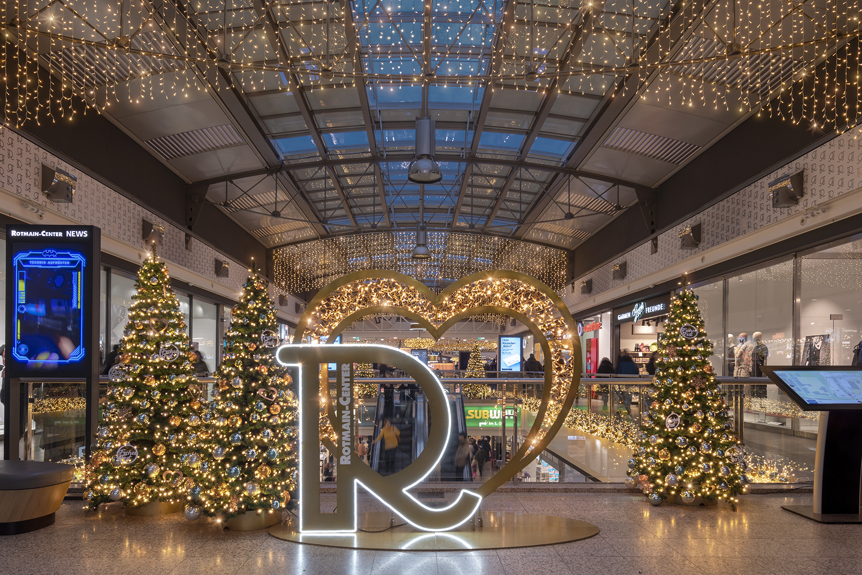Cuore luminoso tra gli alberi decorati di Rotmain Center